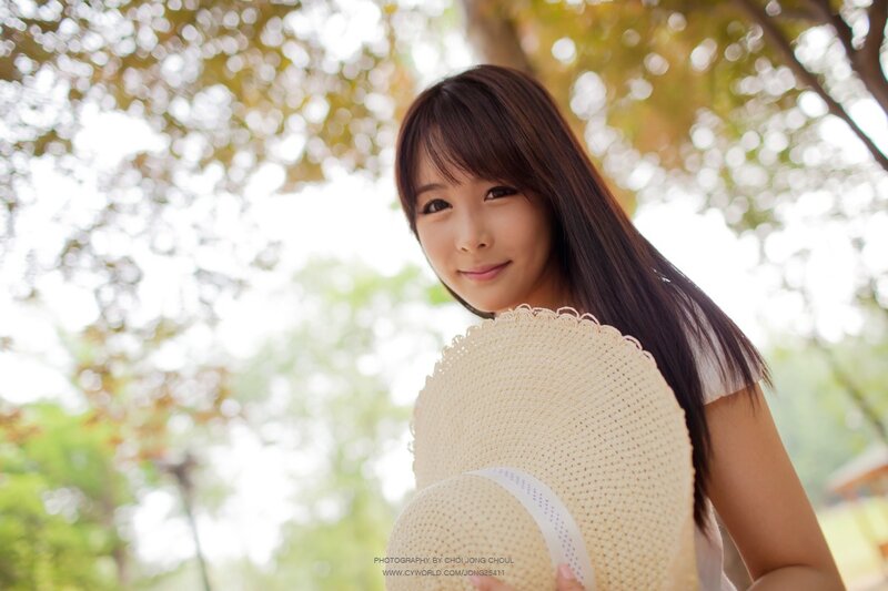 woman holding straw hat outdoors