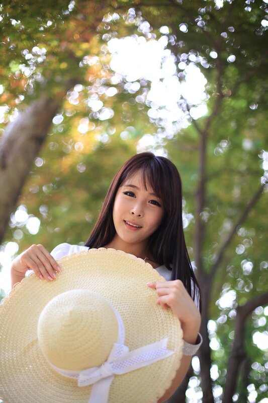 woman holding straw hat outdoors