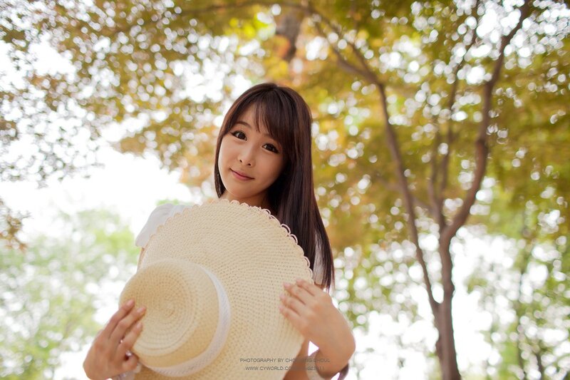woman holding straw hat outdoors