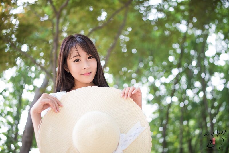 woman holding straw hat outdoors