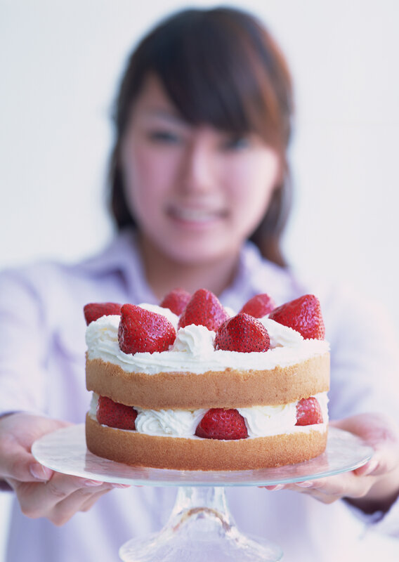 woman holding strawberry cake