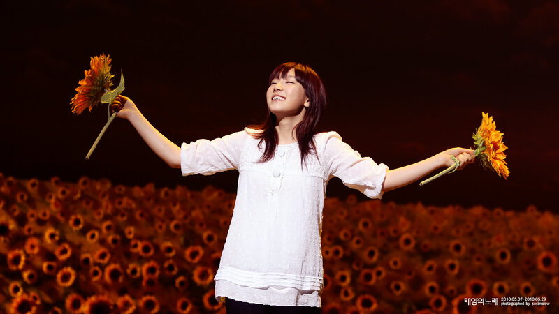 woman holding sunflowers on stage