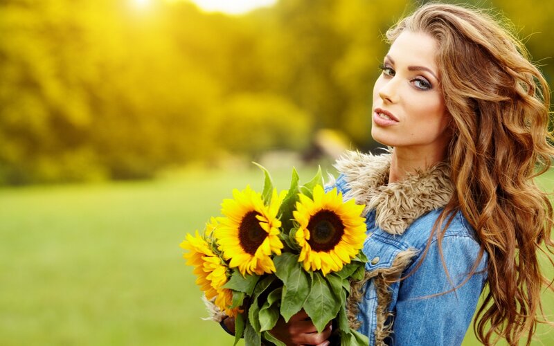 woman holding sunflowers outdoors