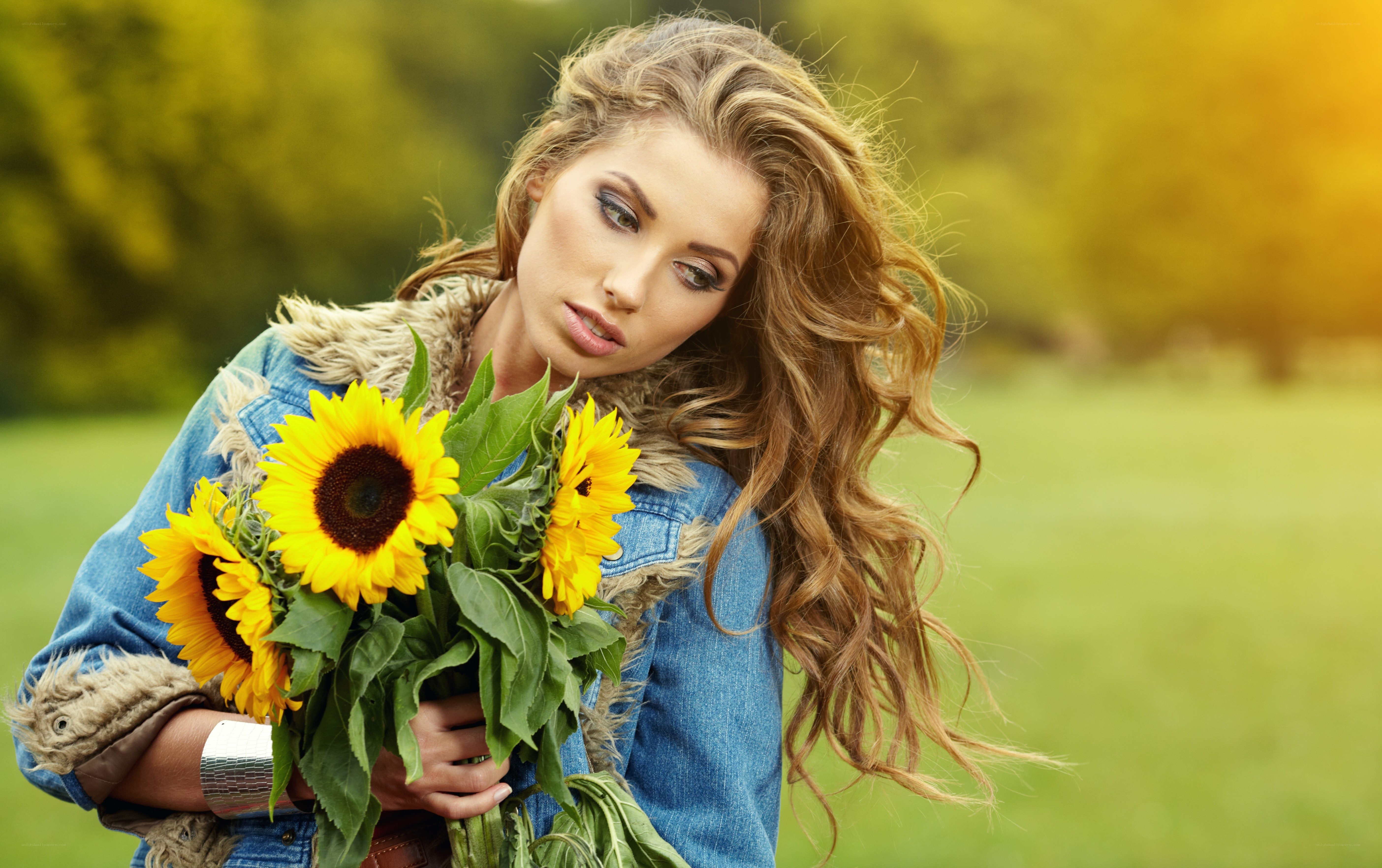 Woman holding sunflowers outdoors