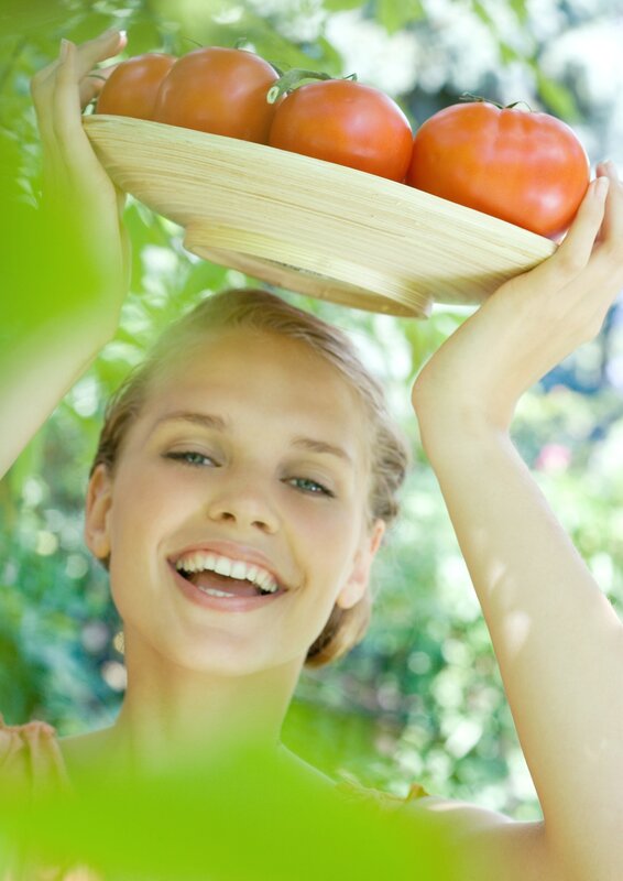 woman holding tomatoes outdoors