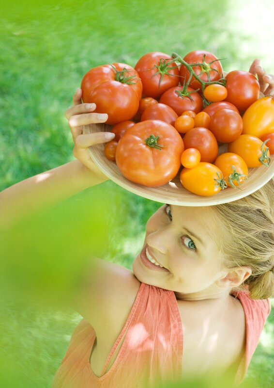 woman holding tomatoes outdoors