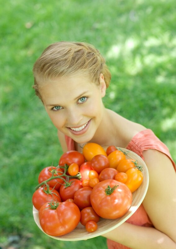 woman holding tomatoes outdoors