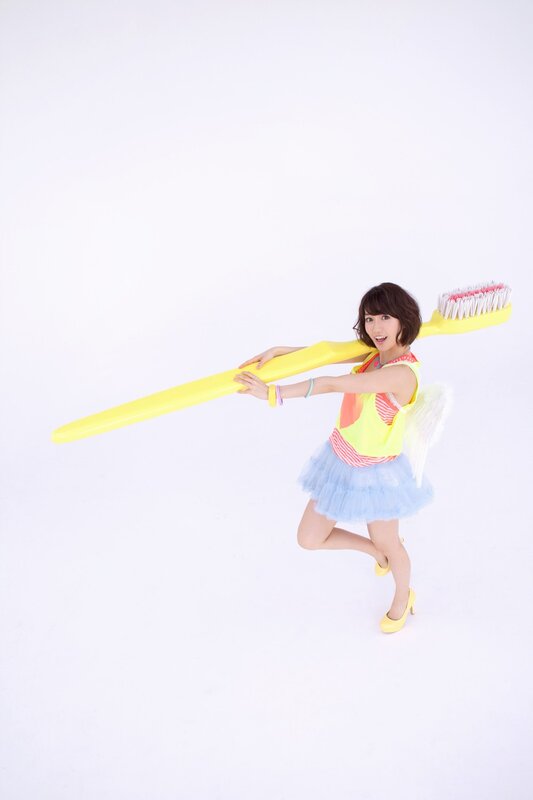 Woman Holding Toothbrush — Yellow