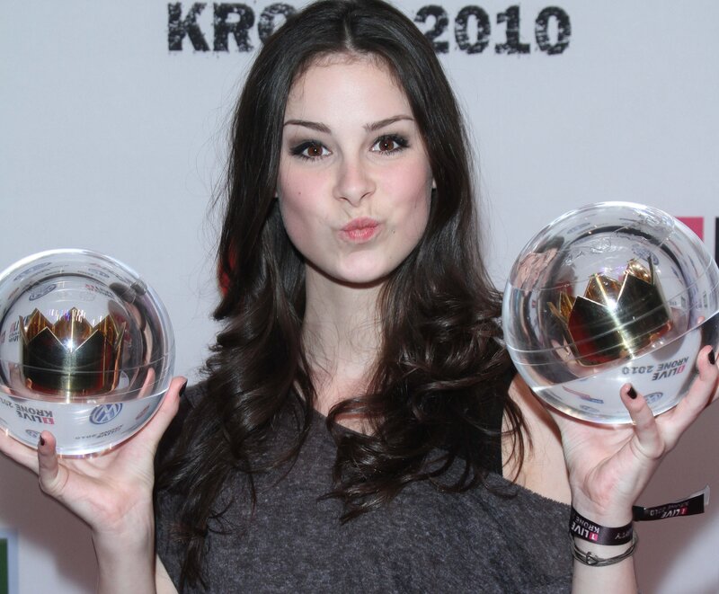 woman holding two awards