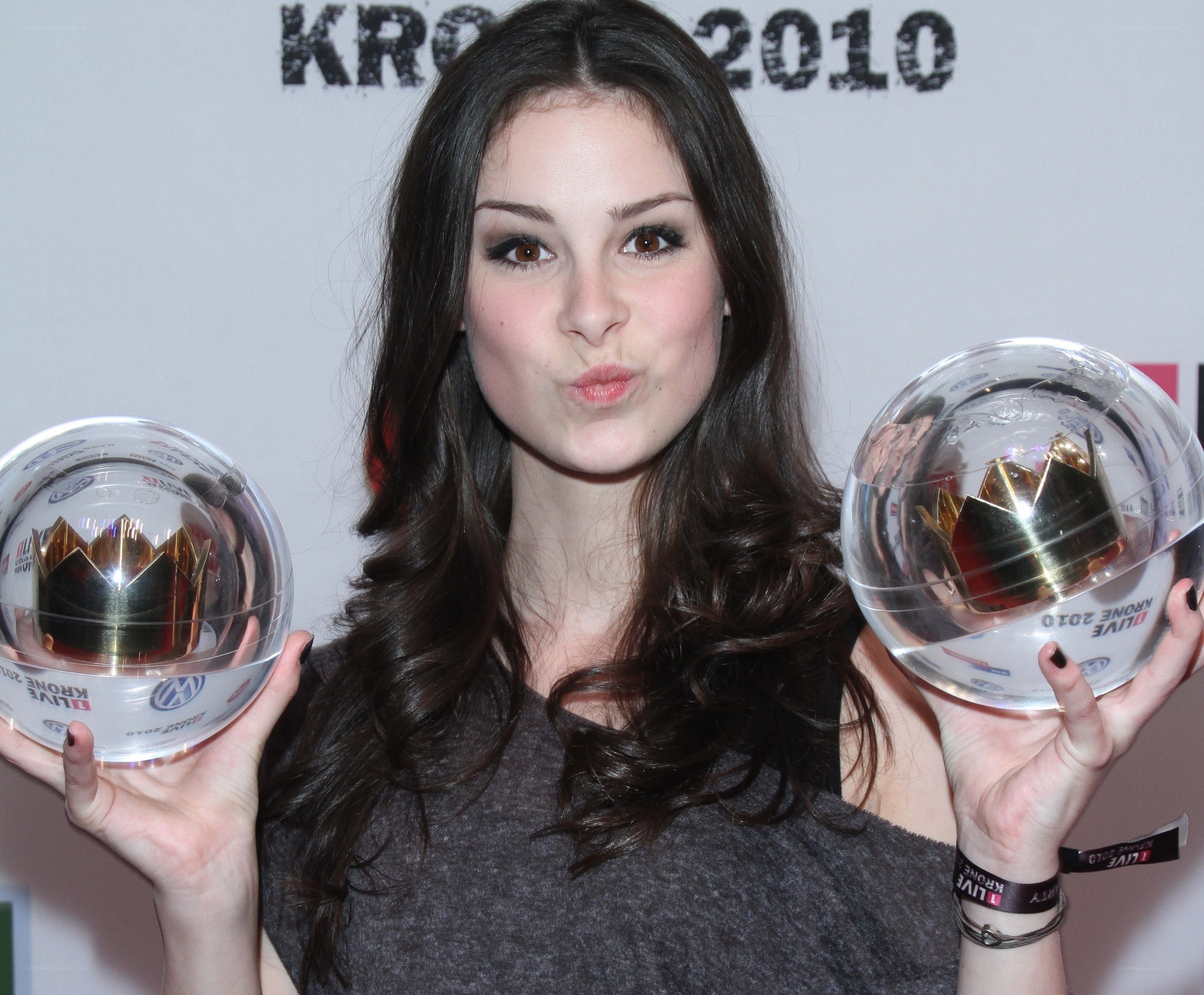 woman holding two awards