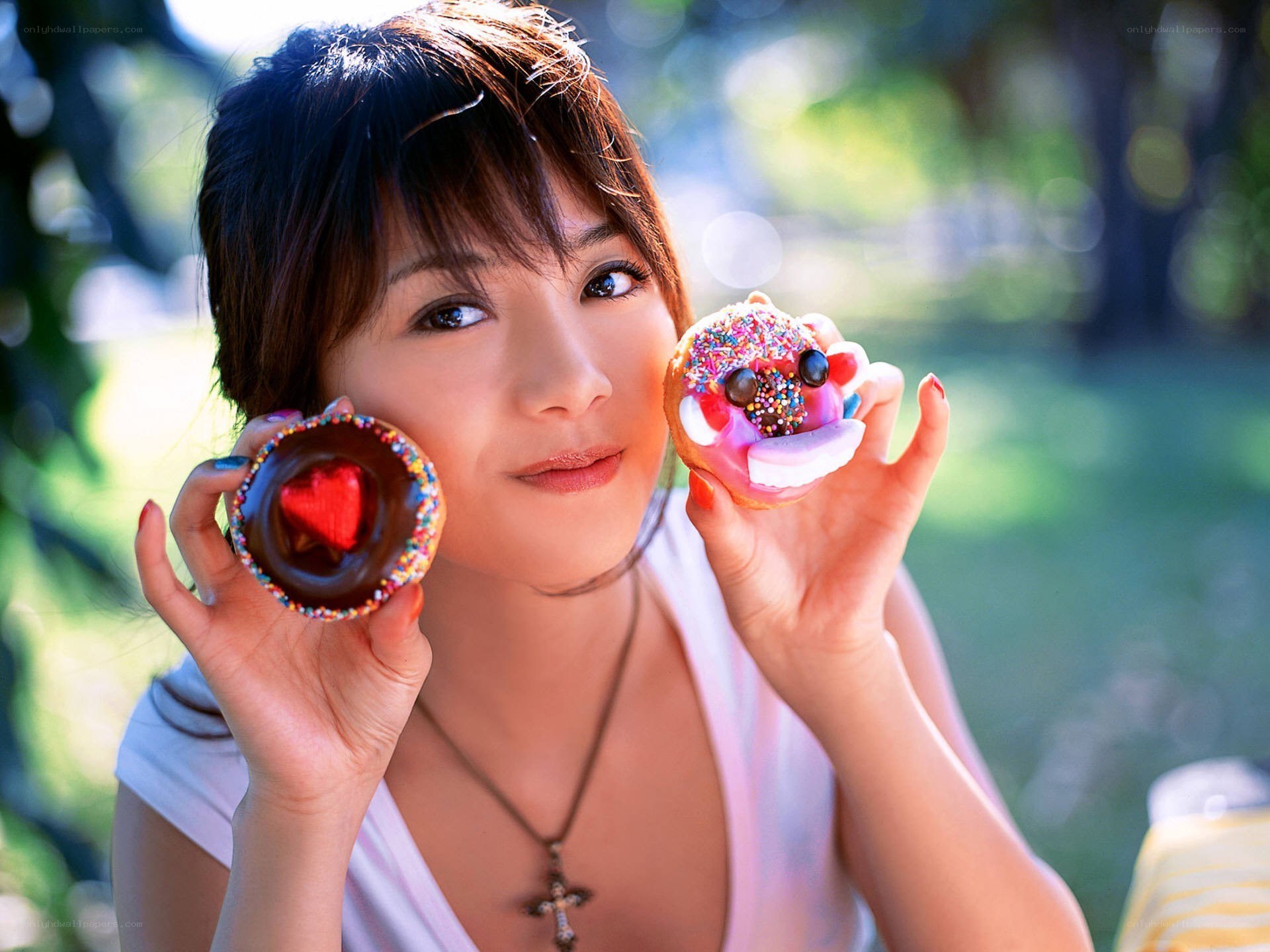 Woman holding two decorated donuts