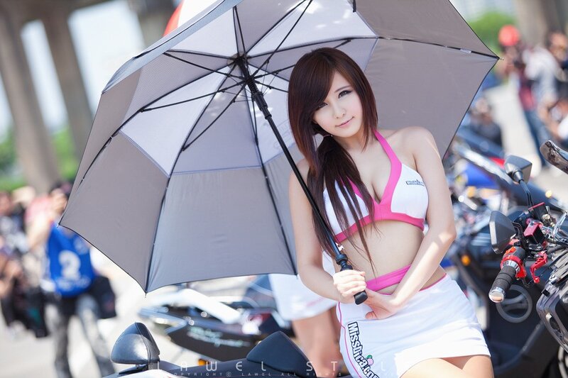 Woman holding umbrella at motorcycle event