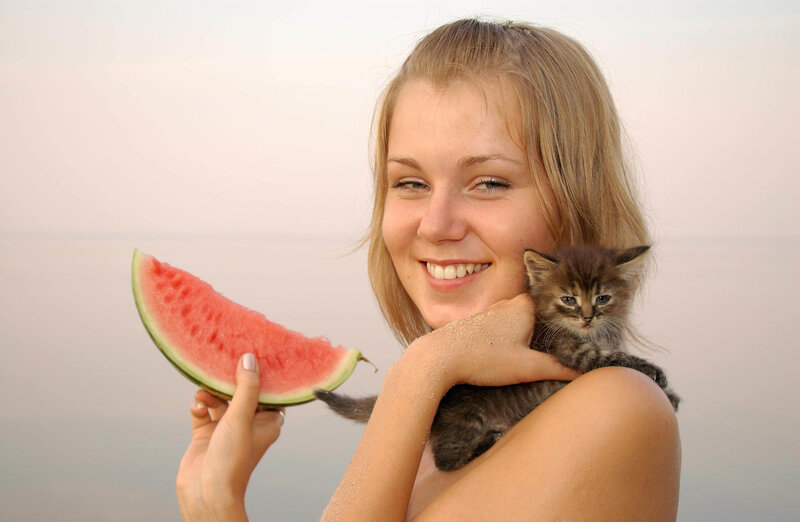 Woman holding watermelon and kitten