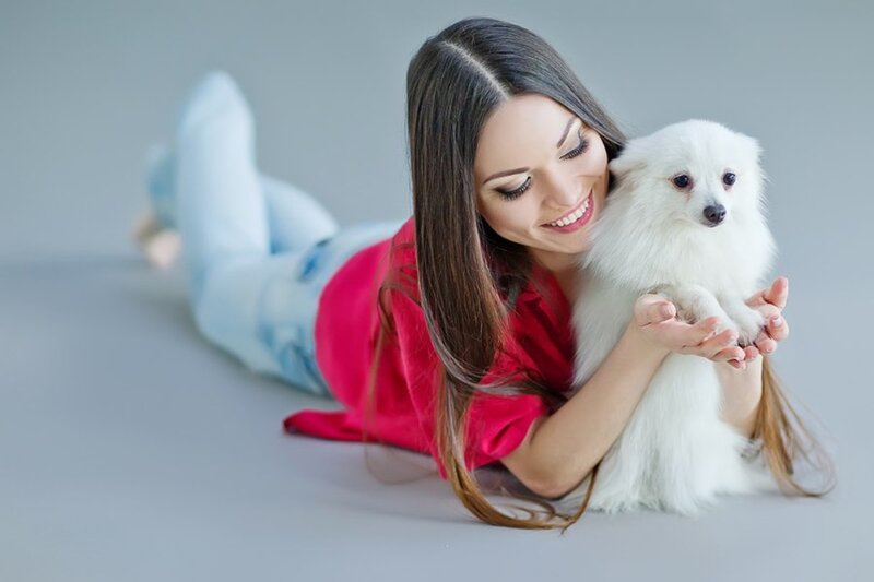 Woman Holding White Dog — Calm, Photograph, Jeans