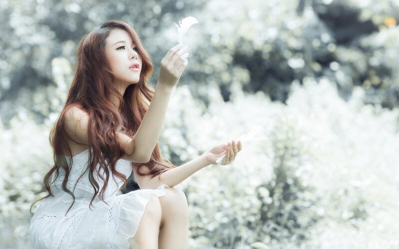woman holding white feathers