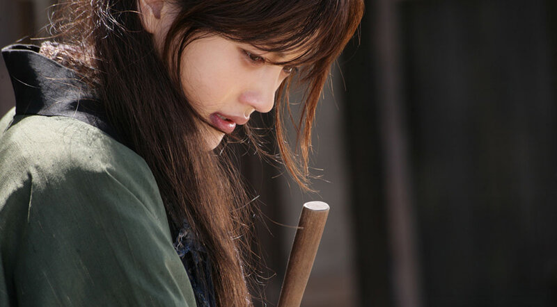 woman holding wooden staff