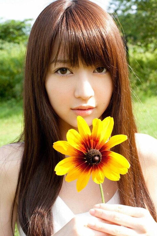 woman holding yellow flower
