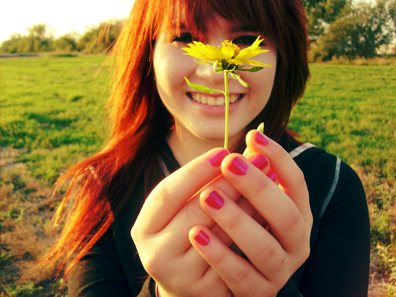 woman holding yellow flower