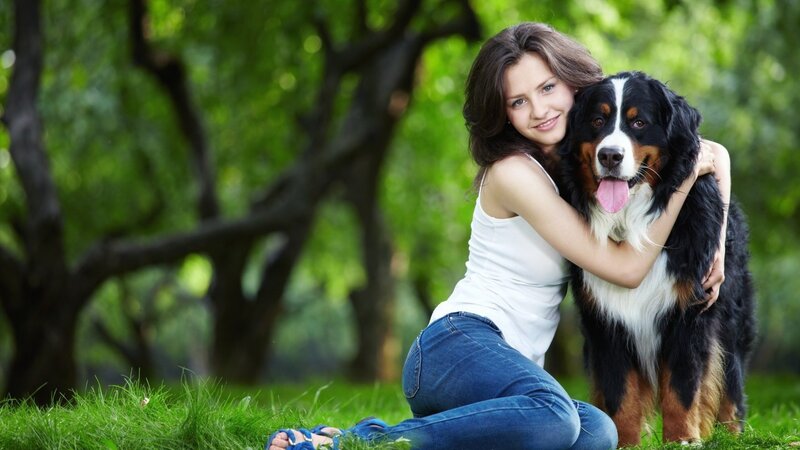 woman hugging dog in park
