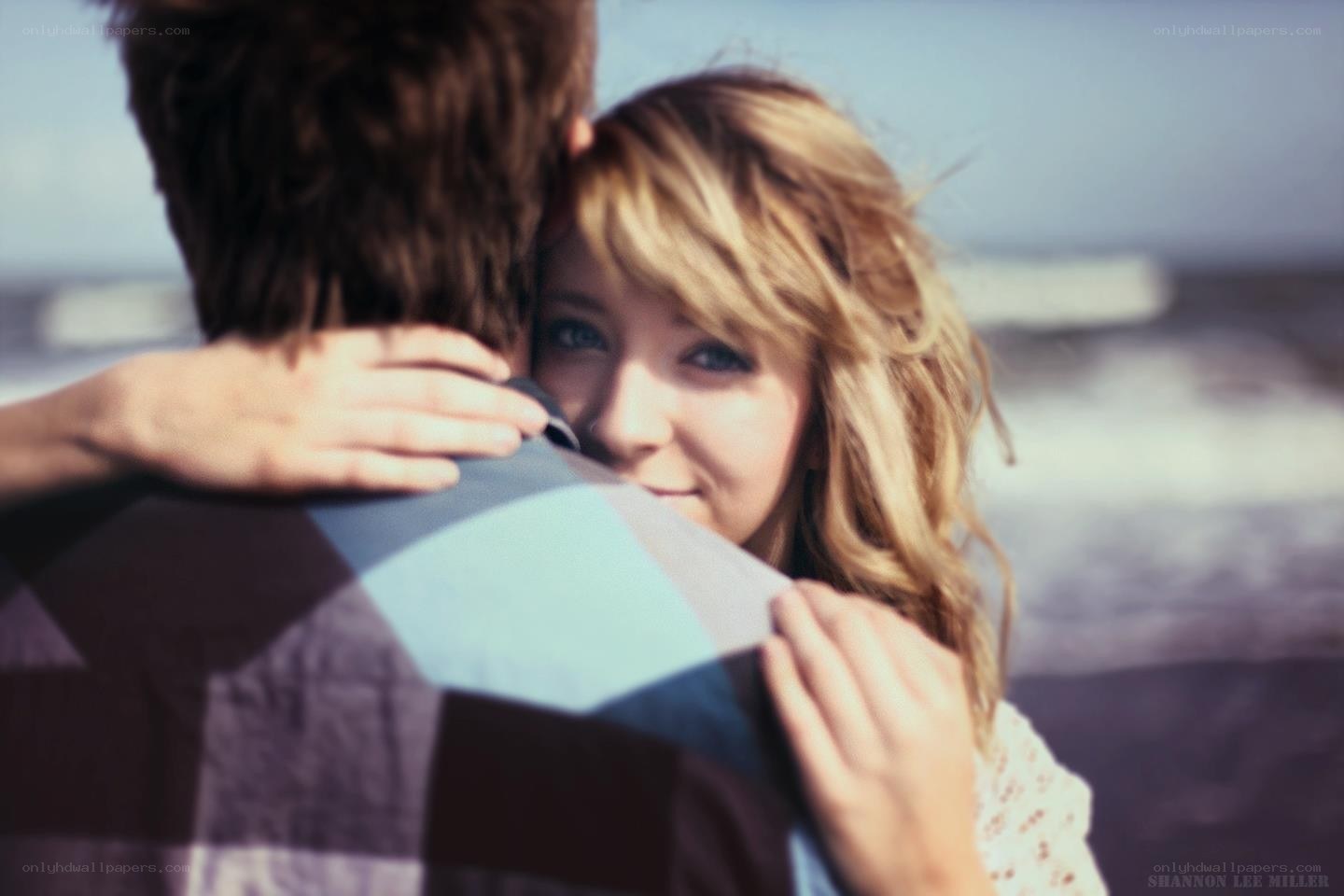 woman hugging man at beach