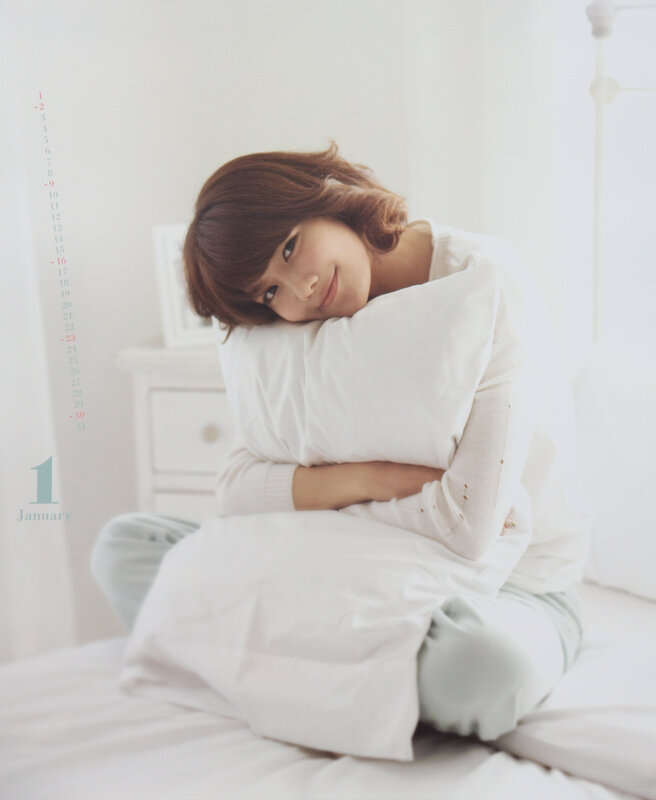 woman hugging pillow on bed