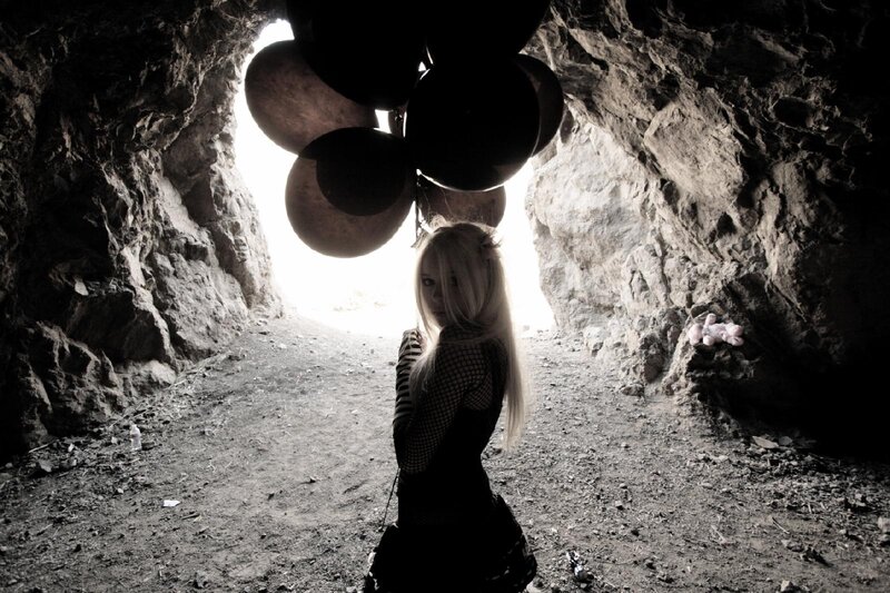 woman in a cave with balloons