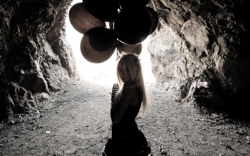 woman in a cave with balloons