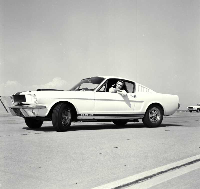 Woman in a classic white Mustang