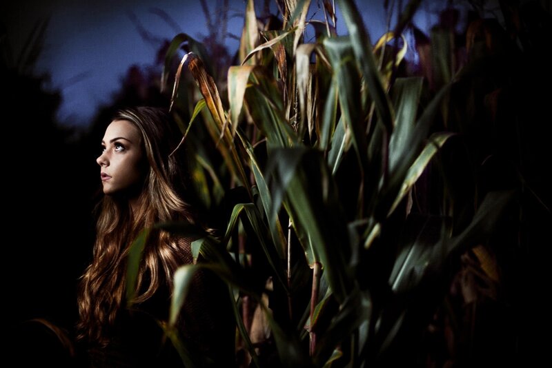 woman in a cornfield at night