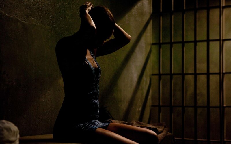 woman in a dimly lit cell