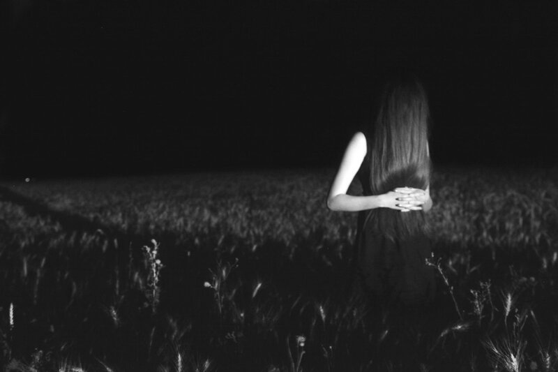 Woman in a field at night