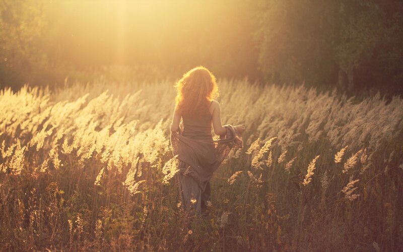 woman in a field at sunset