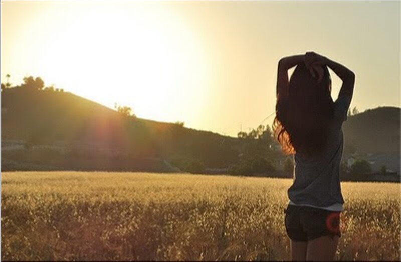 Woman in a field at sunset