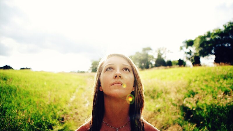 woman in a field looking up