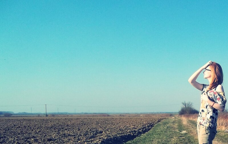 Woman in a field under blue sky