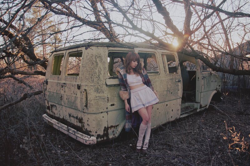 woman in a field with an old van