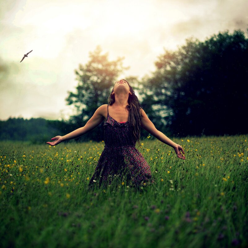 Woman in a field with arms outstretched