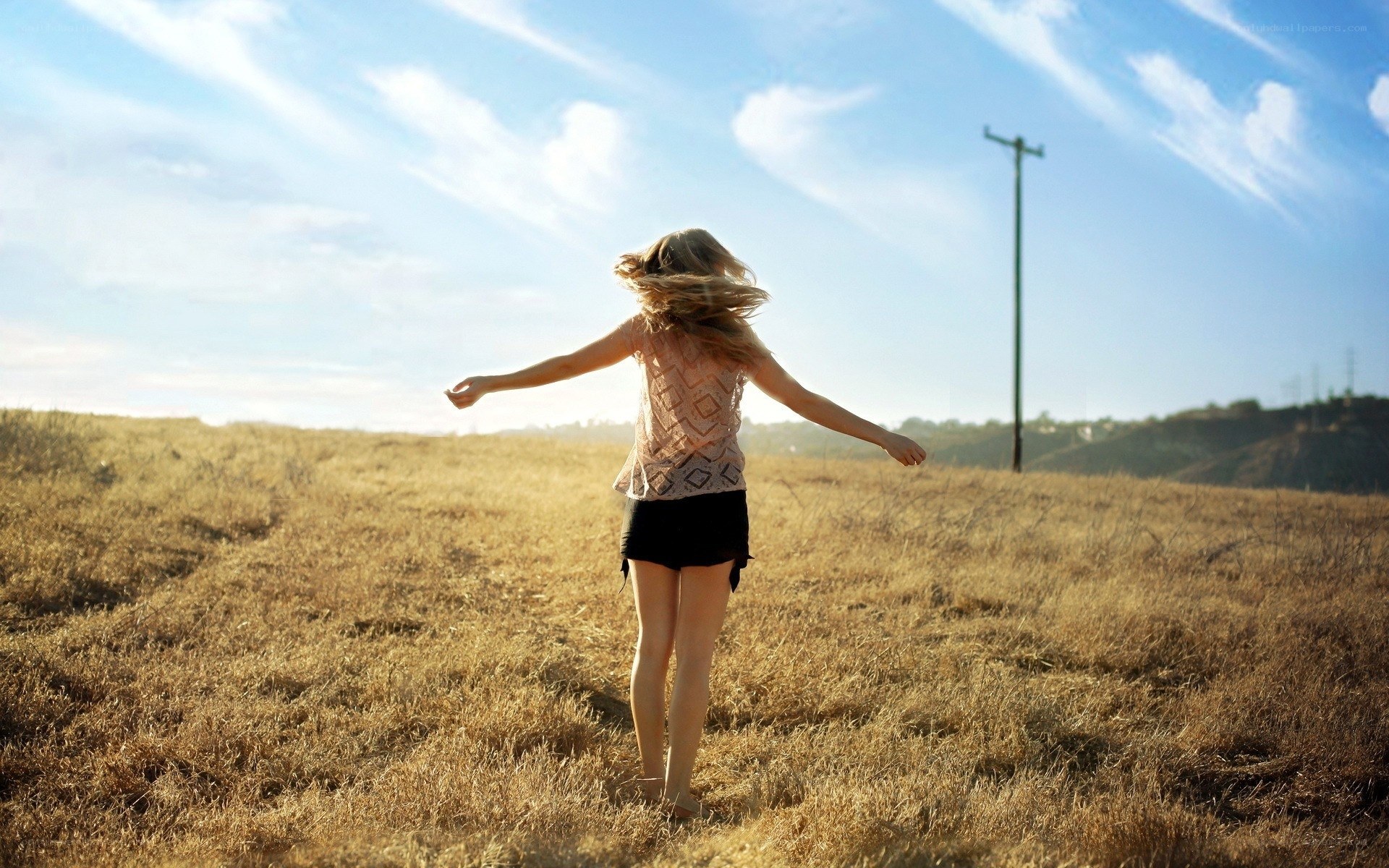 Woman in a field with arms outstretched