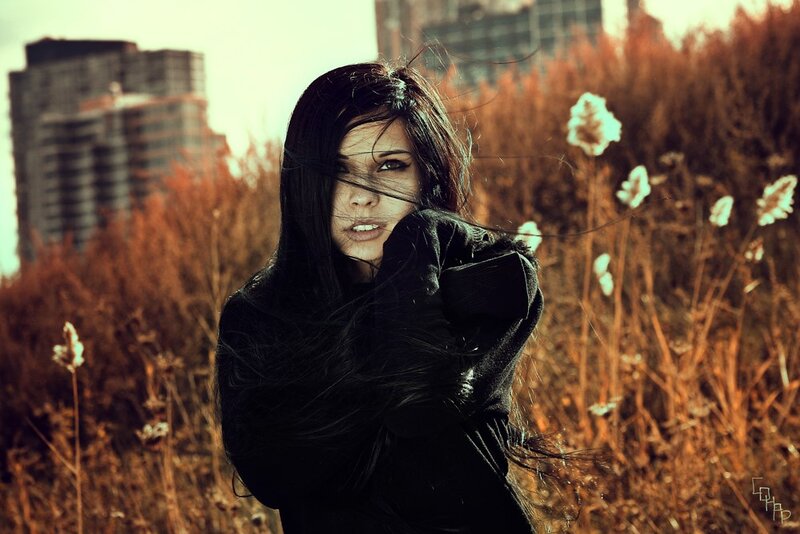 woman in a field with buildings