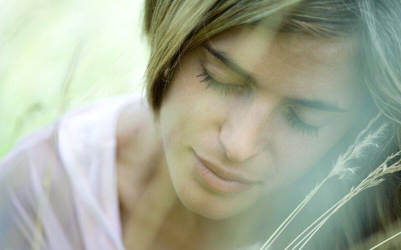 woman in a field with eyes closed