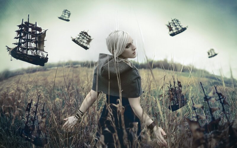 woman in a field with floating ships