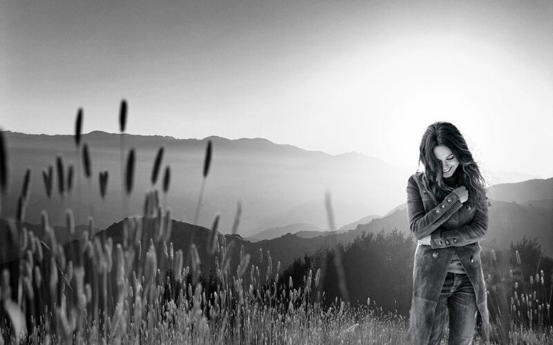 woman in a field with mountains
