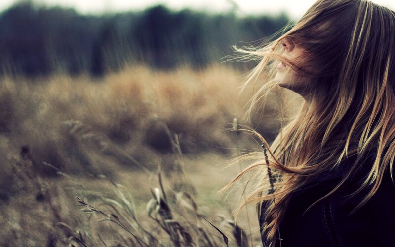 woman in a field with wind