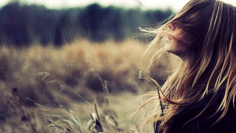 woman in a field with wind