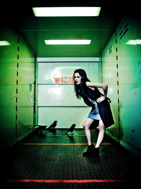 Woman in a green-lit corridor