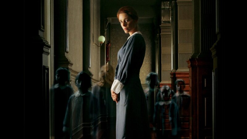 woman in a hallway with ghosts