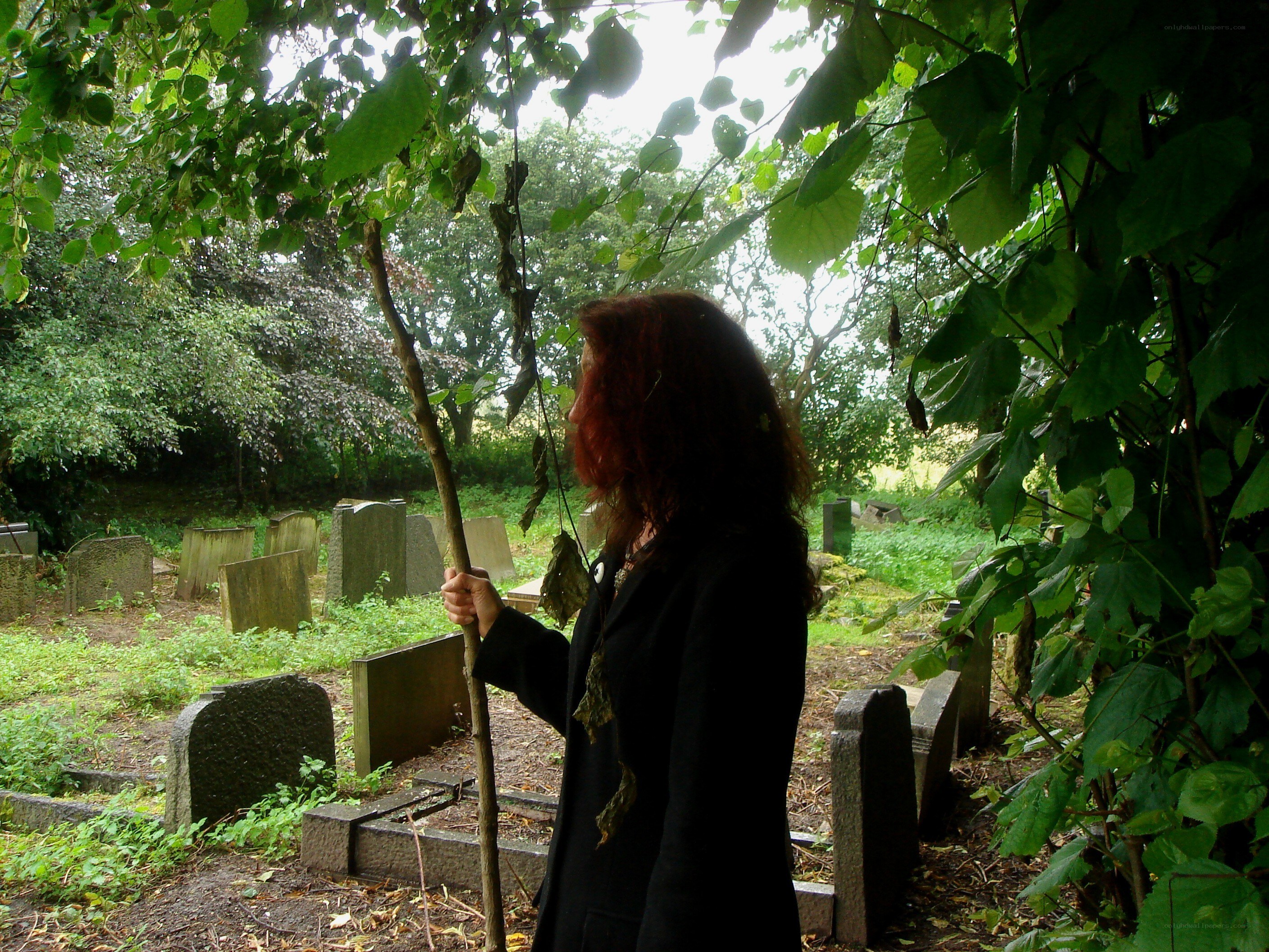 Woman in a leafy graveyard