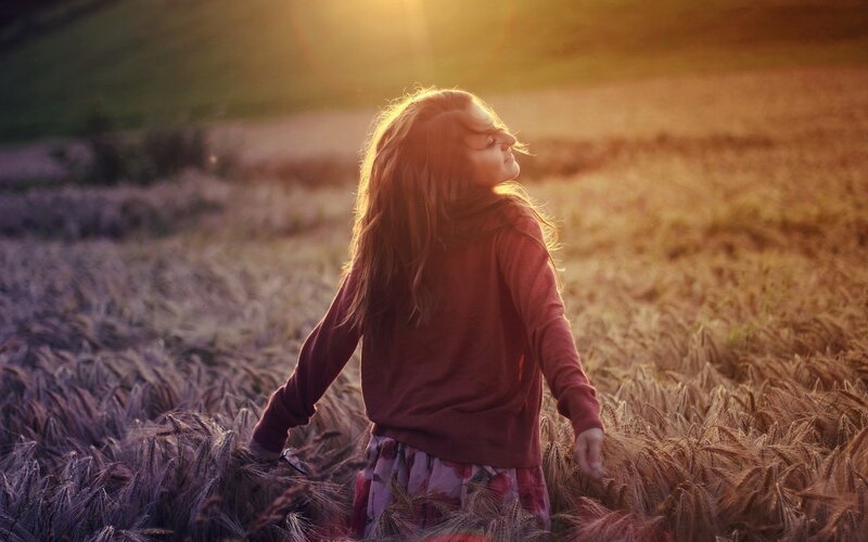 woman in a wheat field at sunset
