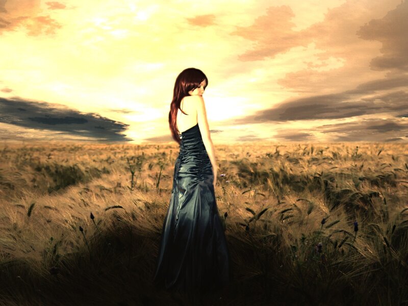Woman in a wheat field at sunset