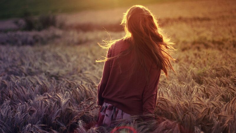 woman in a wheat field at sunset